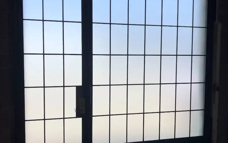 Backlit frosted glazing in a steel grid frame, private from both sides.