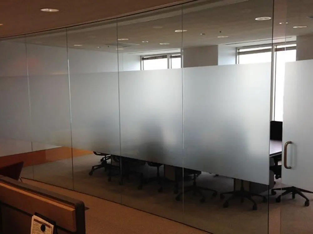 Frosted privacy film on conference room partitions, screening the table while daylight carries through.